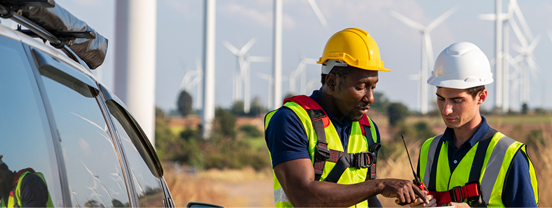 person working in front of wind turbine