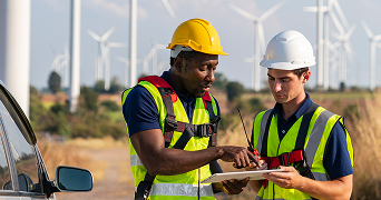 person working in front of wind turbine