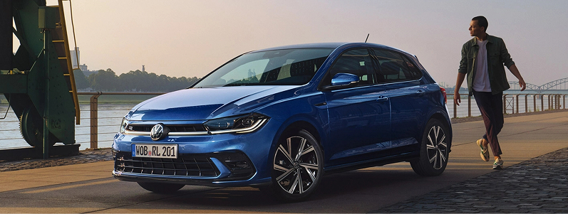 person standing next to a blue car